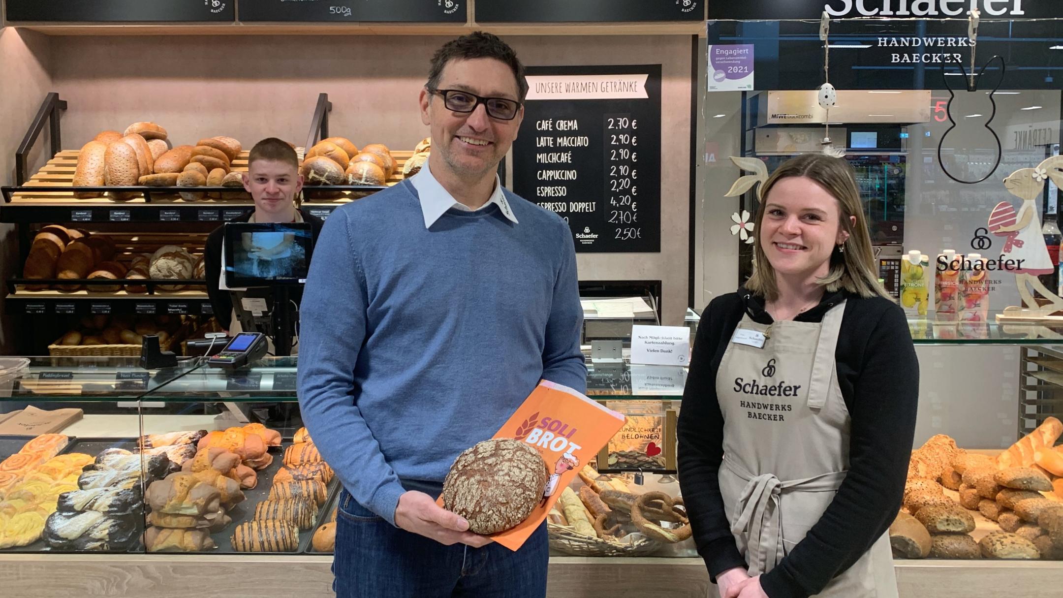 Bäckermeister Sebastian Schaefer präsentiert das Soli-Brot mit seinen Auszubildenden Melanie Wagenknecht und Nico Schiestel.